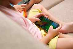 女孩上瘾移动手机亚洲姐妹玩游戏看漫画智能手机沙发首页