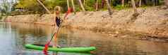 站桨董事会女人桨登机湖站快乐paddleboard蓝色的水行动拍摄年轻的女人桨董事会横幅长格式