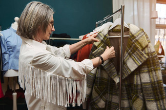 欧洲成熟的女人时尚的时尚设计师裁缝裁缝站服装储藏室衣架衣服准备好了变更