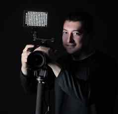专业摄影师相机三脚架孤立的黑色的背景
