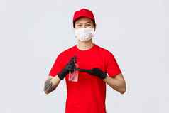 微笑交付男人。红色的帽t恤穿医疗面具手套应用手洗手液保护科维德病毒爆发快递在乎客户洗手液工作