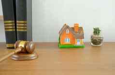 法官槌子法律书房子模型木桌子上真正的房地产争端财产拍卖概念