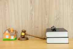 法官槌子法律书房子模型木桌子上真正的房地产争端财产拍卖概念