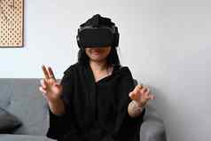 退出亚洲女孩穿虚拟现实耳机看视频玩视频游戏触摸空气