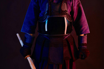 关闭拍摄剑道战斗机穿护甲传统的和服练习武术艺术shinai竹子剑黑色的背景