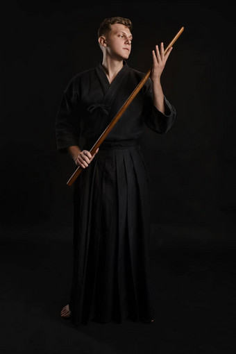 <strong>剑道</strong>老师穿传统的日本和服练习武术艺术shinai竹子<strong>剑</strong>黑色的工作室背景