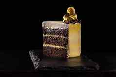 一块黄色的生日蛋糕装饰奶油装饰蛋糕黑色的背景