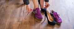 业务女人交流高高跟鞋舒适的鞋子工作场所特写镜头女手需要黑色的鞋子把彩色的运动鞋办公室长工作一天