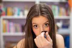 十几岁的女孩粉末鼻子油漆化妆特写镜头视图