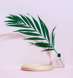 轮木平台显示化妆品产品玻璃花瓶绿色棕榈叶