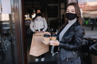 有吸引力的女客户脸面具站在户外咖啡馆食物咖啡背景收银员面具等待客户规范检疫