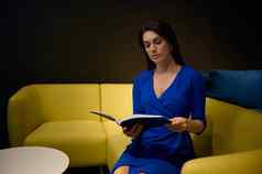 拉美裔漂亮的女人优雅穿着蓝色的衣服坐在黄色的沙发翻转目录选择软垫家具家具设计商店