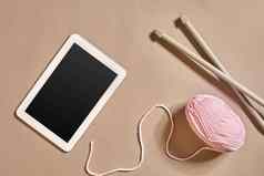 粉红色的针织纱球针织针平板电脑黑色的屏幕前视图