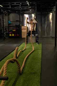 绳子仓库健身绿色男人。草培训健身房肌肉发达的年轻的强大的强度物理健康的活动人肌肉交叉地面持有