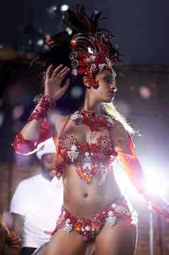 令人陶醉的红色的拍摄美丽的桑巴舞者执行狂欢节乐队