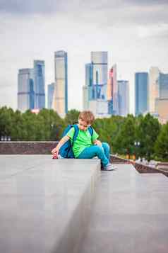 男孩玩玩具坐着步骤开放空气背景摩天大楼高层建筑旅程生活方式城市