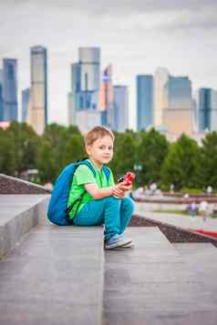 男孩玩玩具坐着步骤开放空气背景摩天大楼高层建筑旅程生活方式城市