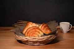温暖的新鲜的黄油羊角面包柳条篮子早餐面包面包店产品咖啡馆概念