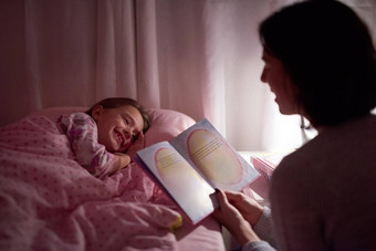 故事火花甜蜜的梦裁剪拍摄女孩说谎床上妈妈读取睡觉前故事