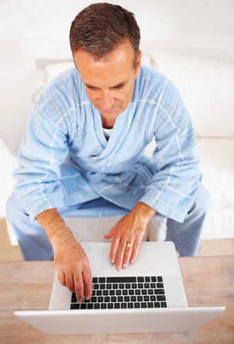 上了年纪的男人。浴袍工作移动PC首页向上视图高级退休男人。工作移动PC首页