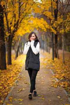 年轻的女人秋天衣服走秋天公园风景如画的秋天树叶