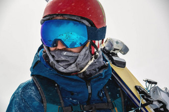 特写镜头肖像滑雪护目镜男人。反射雪山山范围反映了滑雪面具肖像男人。滑雪度假胜地背景山