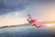 年轻的女人风筝冲浪者游乐设施波技巧海洋体育冲浪板