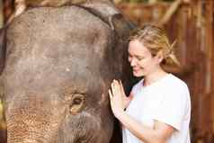 年轻的研究员亚洲大象小腿泰国年轻的eco-tourist微笑轻轻中风年轻的亚洲大象