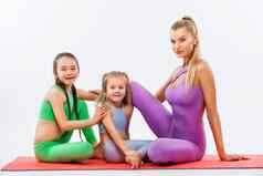 哈达瑜伽孩子们健身年轻的妈妈。教练女儿锻炼体操孤立的白色背景家庭