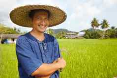 收获时间肖像大米农民持有传统的收获工具泰国