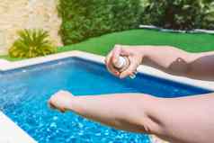 特写镜头年轻的女人的手臂应用防晒霜皮肤游泳池化妆品防止晒伤概念健康皮肤护理