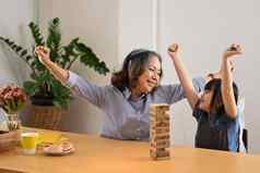 喜出望外亚洲女孩祖母玩木块叠加董事会游戏支出休闲周末首页