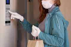 快递员的手黑色的医疗手套交付包裹纸袋通过疫情coronovirus科维德安全交付在线订单疫情