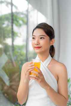 美丽的美女人亚洲可爱的女孩感觉快乐喝橙色汁好健康早....