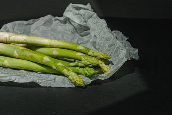 新鲜的绿色芦笋谎言白色羊皮纸黑暗灰色的背景适当的营养生活方式的地方文本