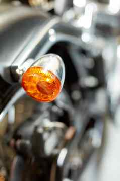 特写镜头后视图尾灯摩托车橙色把光模糊黑色的古董摩托车现代铬运输车辆维护闪亮的经典复古的自定义自行车