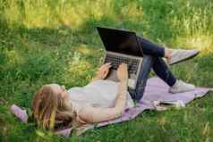 横幅年轻的女孩作品移动PC新鲜的空气公园坐着草坪上概念远程工作工作自由职业者女孩需要课程移动PC微笑