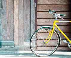 古董黄色的自行车木墙背景生活方式概念的想法