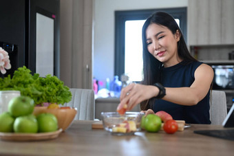 快乐年轻的女人准备健康的沙拉有机水果蔬菜厨房首页