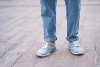 时尚的男人。脚牛仔布牛仔裤运动鞋鞋子站在户外街大理石陶瓷板