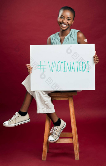 非洲美国科维德接种疫苗女<strong>人</strong>显示持有<strong>海报</strong>肖像微笑黑色的女<strong>人</strong>孤立的红色的工作室背景Copyspace模型促进电晕疫苗标志
