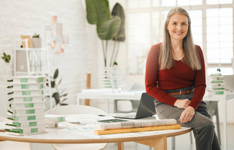 肖像领先的女商人坐着桌子上成熟的女商人设计机构有创意的企业家工作体系结构机构高级企业女商人办公室