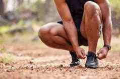 特写镜头运动员系鞋带运行运动男人。准备好了培训在户外自然肌肉发达的跑步者warmup练习有氧运动