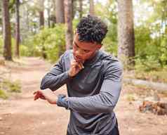 非洲美国男人。检查脉冲穿智能手表跟踪脉冲心跳有氧运动健康运动员设备跟踪重要器官慢跑公园