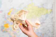 特写镜头木玩具飞机孩子们的手世界地图背景孩子们房间首页童年梦想想象力旅行概念