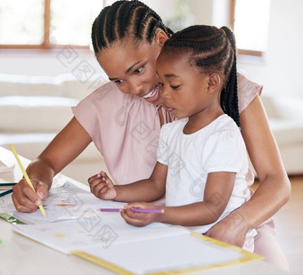 年轻的非洲美国妈妈。帮助女儿家庭作业首页女孩画妈妈首页黑色的女人显示女儿写小女孩学习画