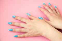 手蓝色的修指甲粉红色的背景平法律
