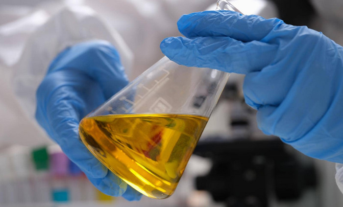 手画科学家持有实验室玻璃器皿金石油液体化