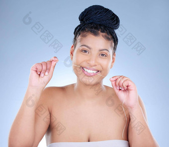 用牙线<strong>清洁牙齿</strong>投资工作室肖像有吸引力的年轻的女人用牙线<strong>清洁牙齿牙齿</strong>蓝色的背景