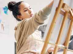 让创造力流低角拍摄有吸引力的年轻的女人绘画帆布工作室
